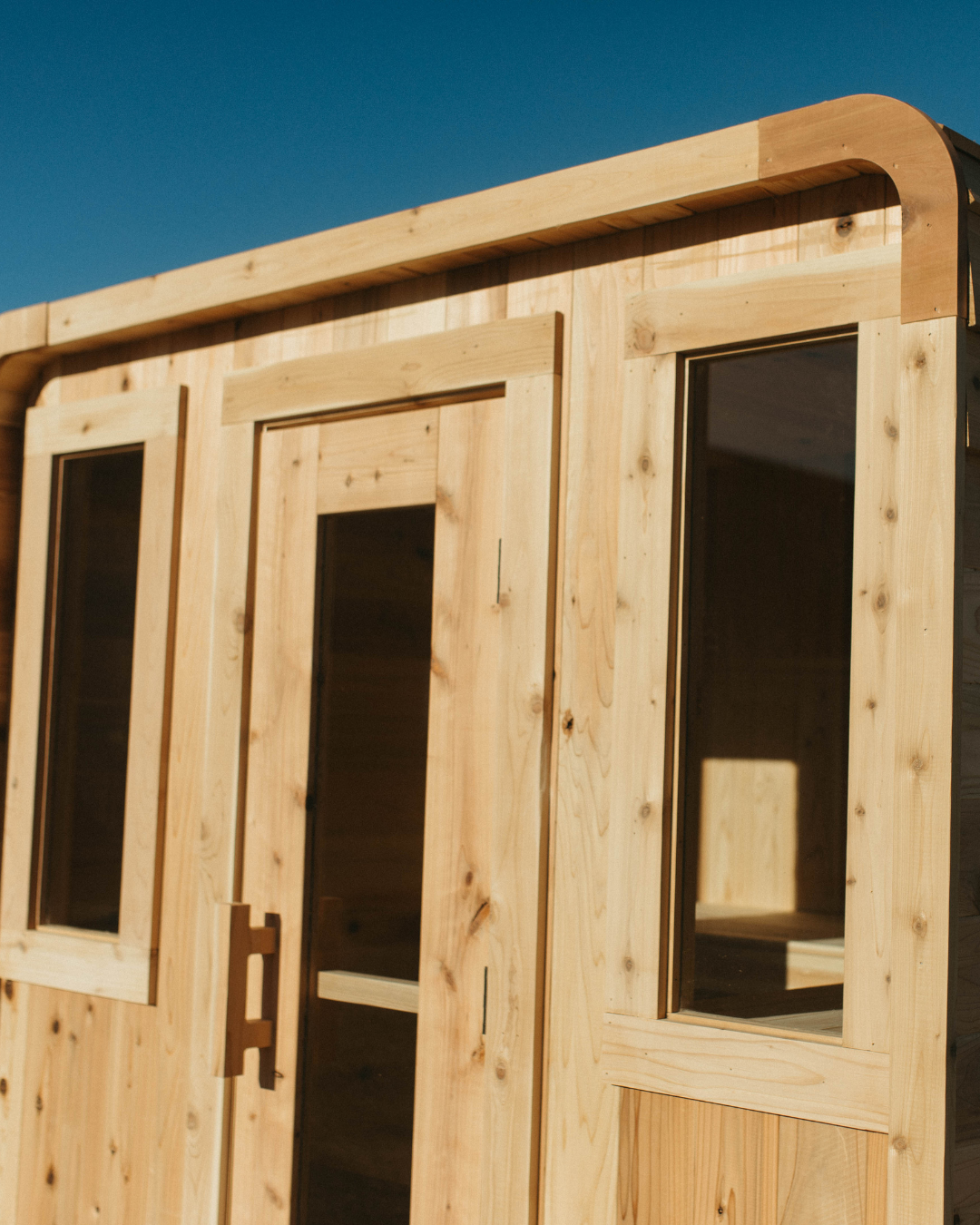 Sweat Cabin Deluxe interior showing L-bench layout and red cedar finish