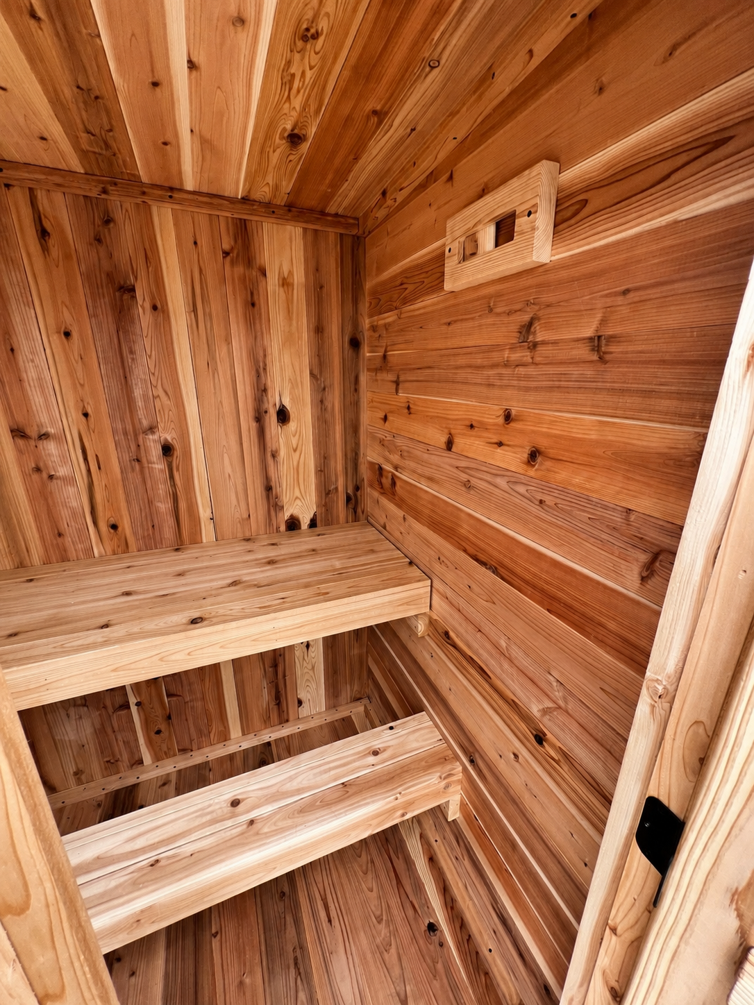 Sweat Kingdom The Ridge two-person outdoor sauna, three-quarter exterior view showing the pitched roof and cedar cladding